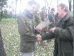 Prowadz�cy polowanie i zarazem prezes ko�a wr�cza dyplom kr�lowi polowania .